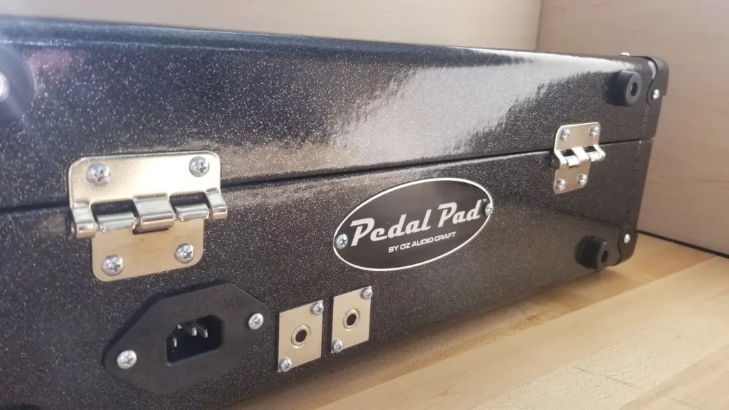 A Pedal Pad pedalboard with audio and power ins and outs and the Pedal Pad logo prominently featured