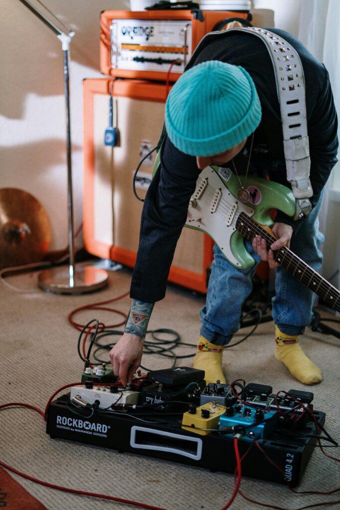 a guitar player testing his pedals after connecting his pedalboard to his amp