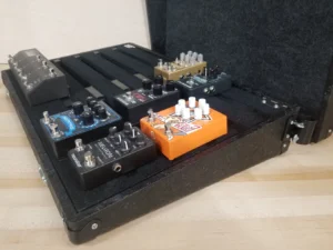A Pedal Pad pedalboard with pedals on deck.